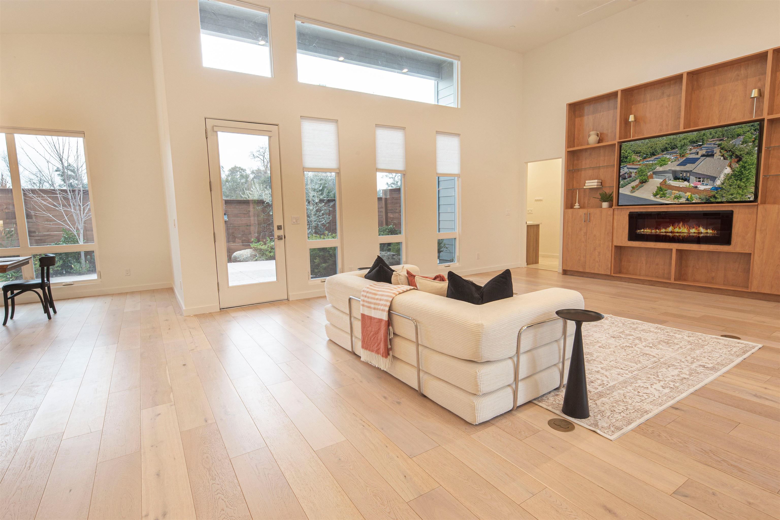 18870 Old Bridge Road Jamestown, CA 95327 - Photo 10 of 57 Living area featuring a glass covered fireplace, a towering ceiling, and light wood-style floors