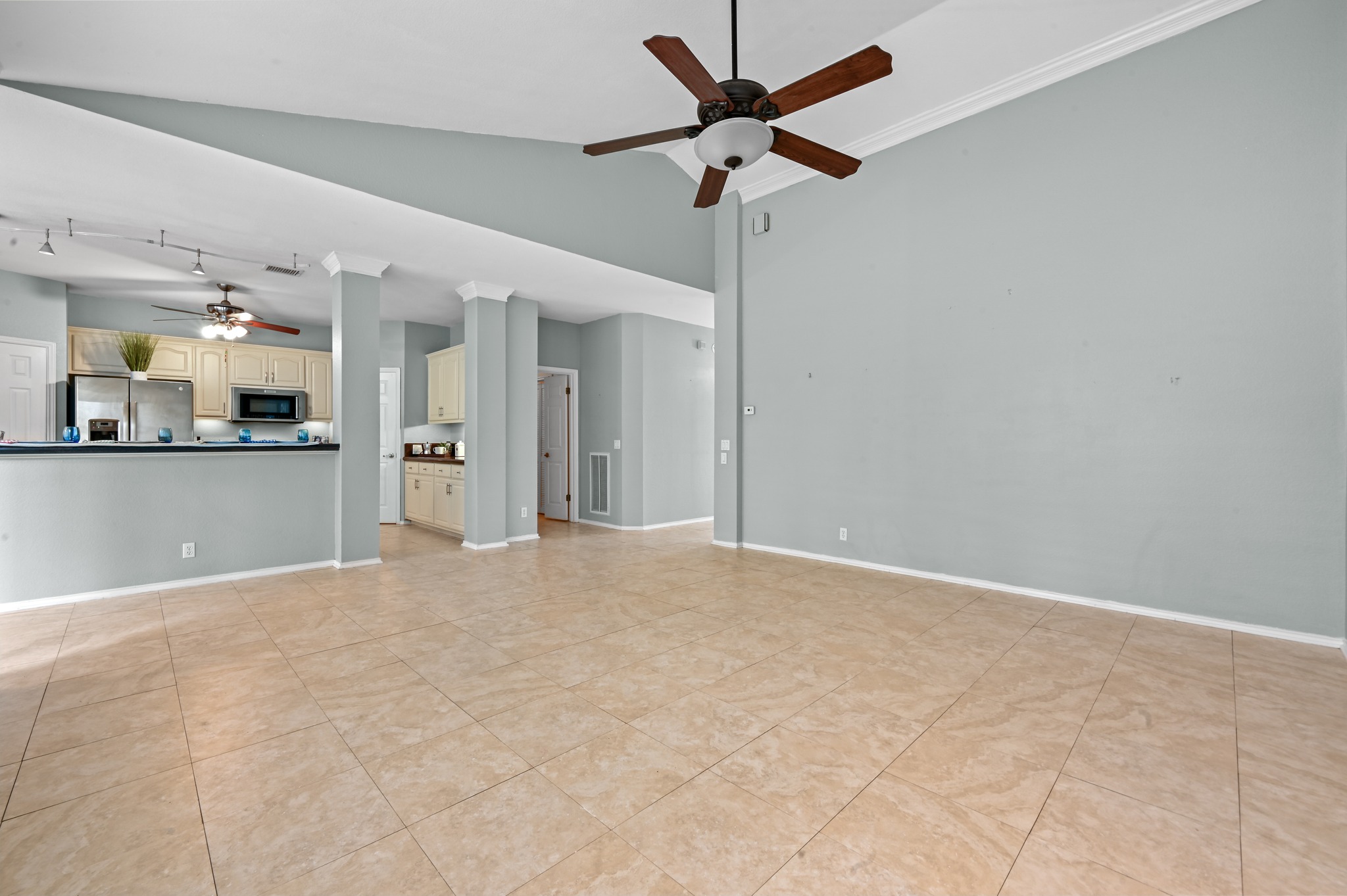 5313 Moon Shadow Drive Austin, TX 78735 - Photo 13 of 30 Spacious living area featuring tile flooring, vaulted ceilings, a ceiling fan, and crown molding