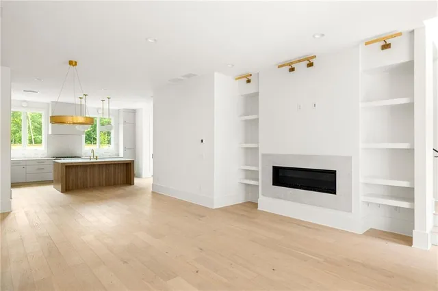 a view of an empty room with a cabinet and a kitchen view