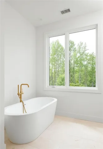 a white bath tub sitting in a bathroom next to a window
