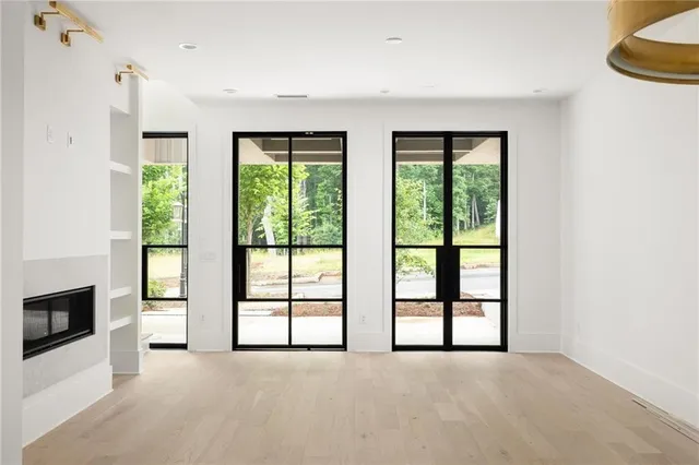 a view of an empty room with a fireplace and a window