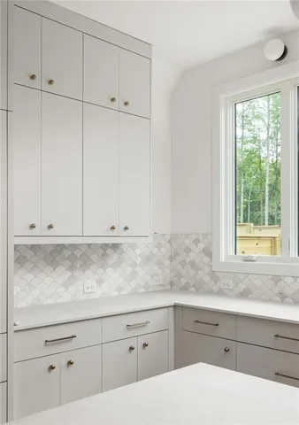 a kitchen with granite countertop white cabinets and window