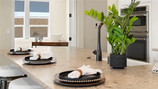 a large kitchen with stainless steel appliances kitchen island granite countertop a sink and a wooden floor