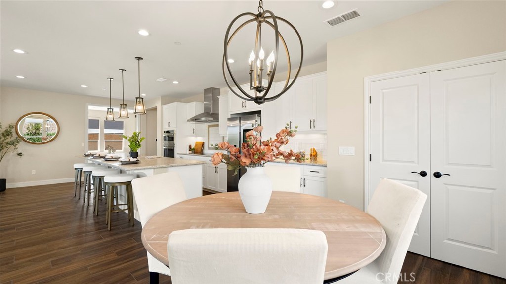 867 Trail View Place Nipomo, CA 93444 - Photo 20 of 71 a dining room with wooden floor a chandelier a wooden table and chairs