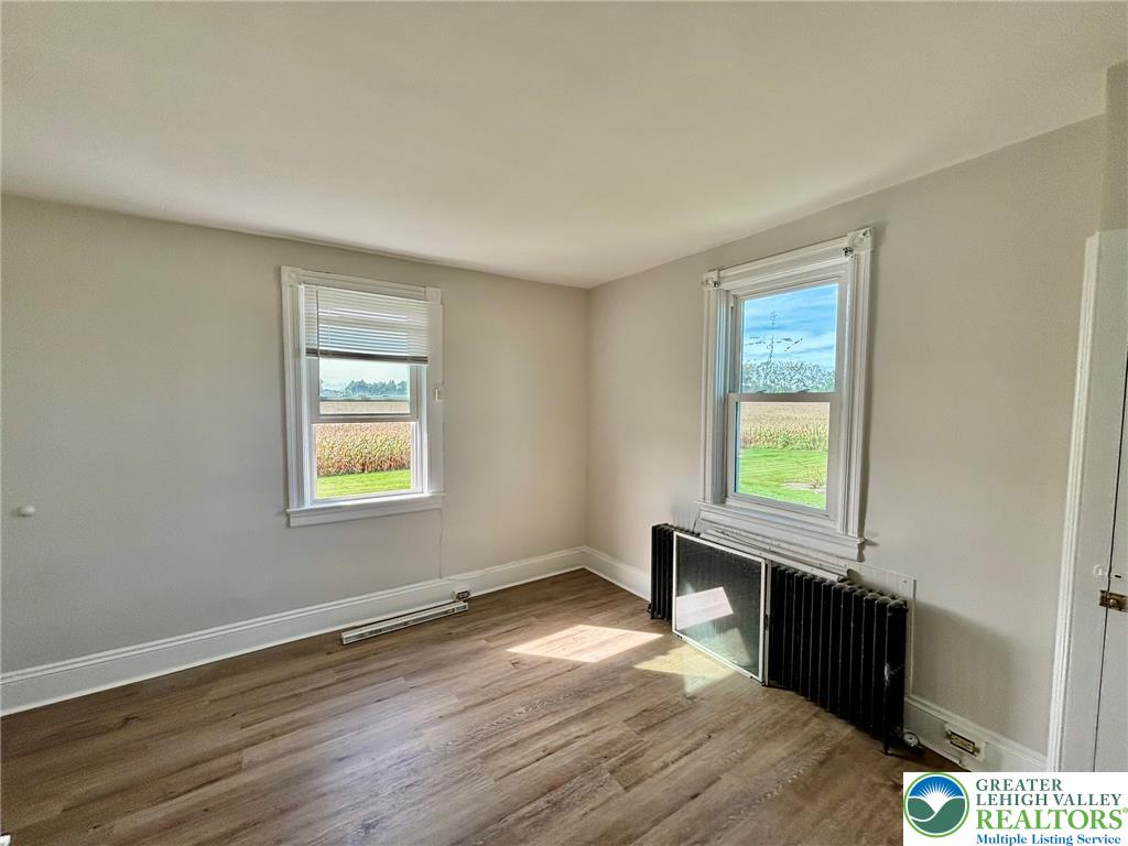 4067 Newburg Road Bethlehem, PA 18020 - Photo 17 of 19 Rich wood flooring and deep baseboards frame serene views of the surrounding rural landscape.