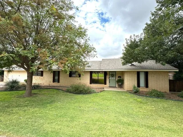 a front view of house with yard and trees around