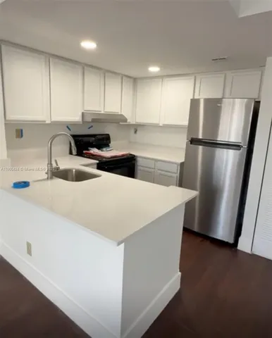 a kitchen with stainless steel appliances a refrigerator a sink a stove a microwave and island