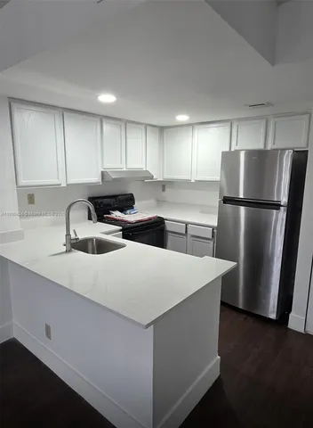 a kitchen with stainless steel appliances a refrigerator sink and cabinets