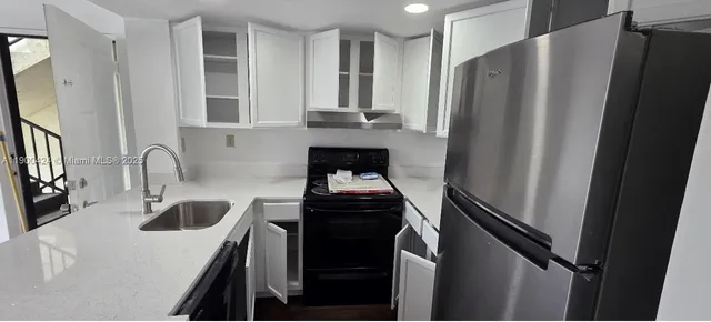 a kitchen with stainless steel appliances a refrigerator sink and stove