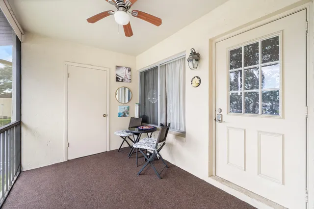 a view of an empty room with window and ceiling fan