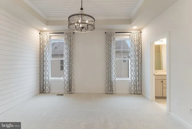 a view of empty room with chandelier and glass door