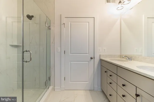 a bathroom with a shower sink and mirror