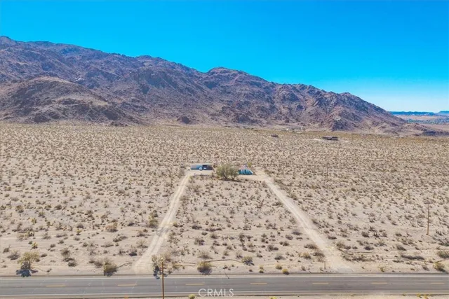 a view of a dry yard with mountain in the background