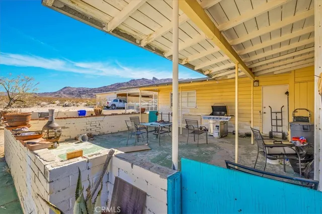 a view of a terrace with furniture and a yard