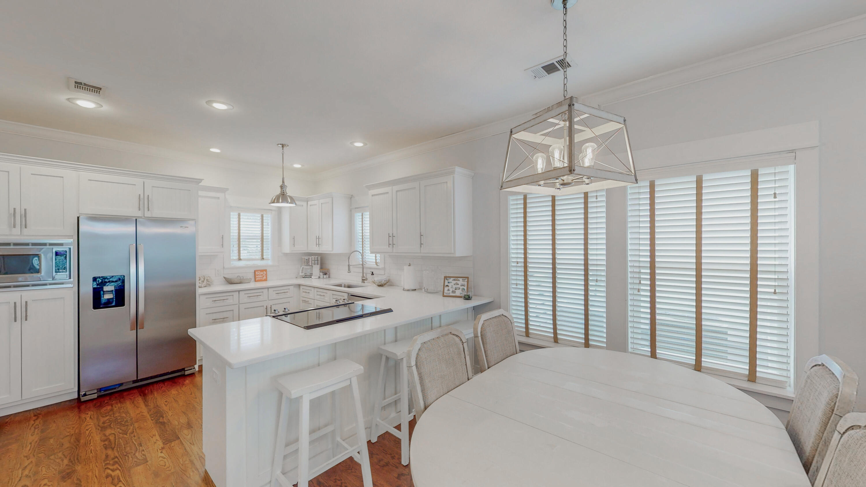 249 Beach Bike Way Inlet Beach, FL 32461 - Photo 11 of 38 a kitchen with stainless steel appliances granite countertop a refrigerator a sink dishwasher a stove and a dining table with wooden floor
