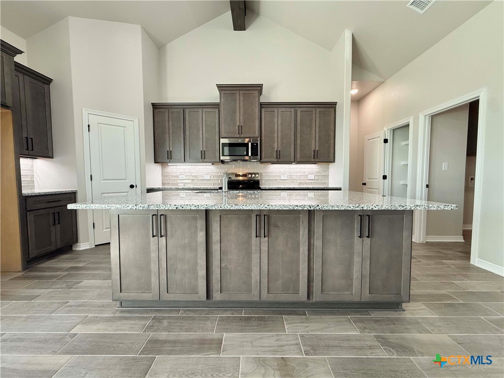 4433 Agave Trail Temple, TX 76502 - Photo 7 of 27 a kitchen with kitchen island granite countertop a sink cabinets and stainless steel appliances