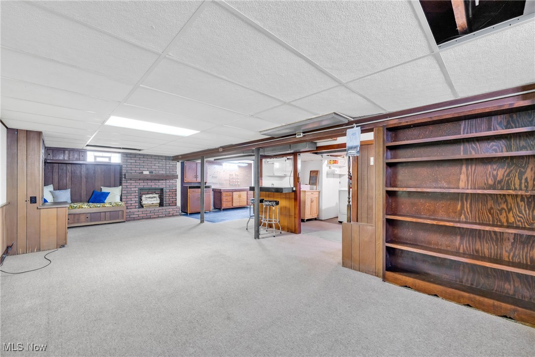 390 Hilliard Road Elyria, OH 44035 - Photo 23 of 30 Below grade area featuring a paneled ceiling, light colored carpet, a fireplace, and wooden walls