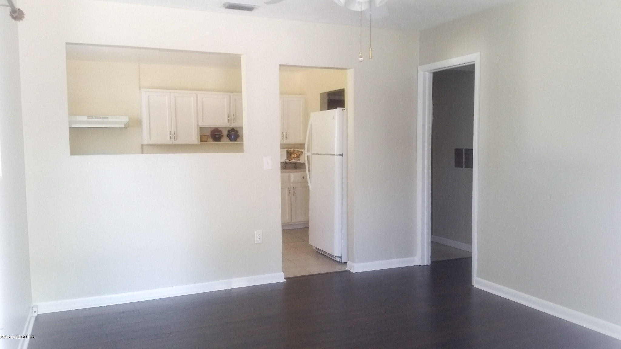 748 Vecuna Road Atlantic Beach, FL 32233 - Photo 3 of 33 an empty room with wooden floor & mirror