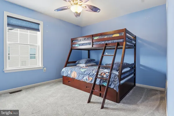 a bedroom with bunk bed and a window