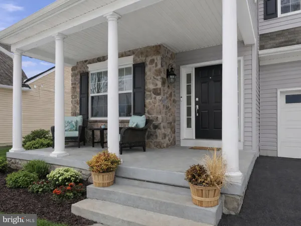 a front view of a house with outdoor seating and flowers