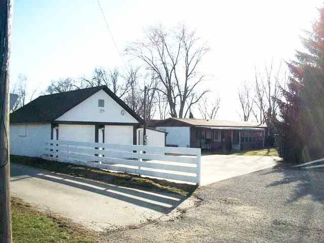 a view of a house with snow on the side of the road