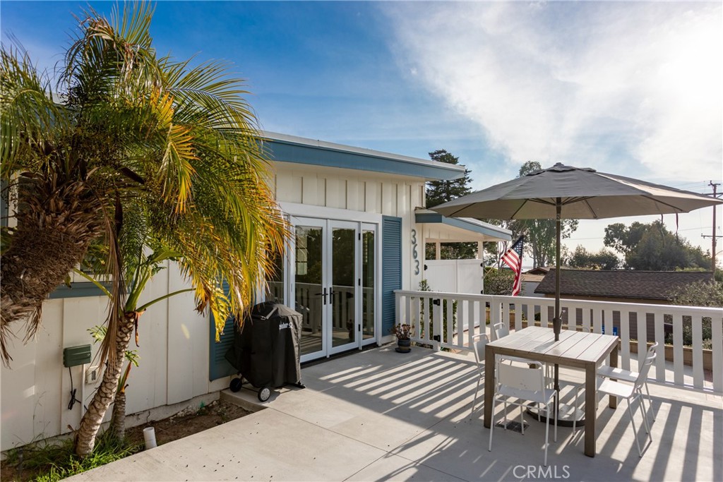 363 Ruby Street Laguna Beach, CA 92651 - Photo 24 of 25 a view of a patio with table and chairs under an umbrella with wooden floor