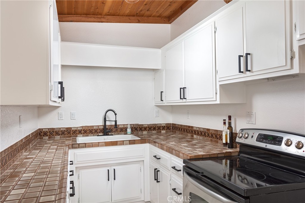 363 Ruby Street Laguna Beach, CA 92651 - Photo 9 of 25 a kitchen with white cabinets a sink and dishwasher