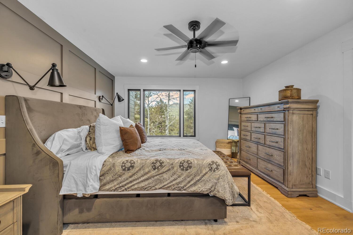 22398 Blue Jay Road Morrison, CO 80465 - Photo 17 of 39 a bedroom with a large bed and a chandelier