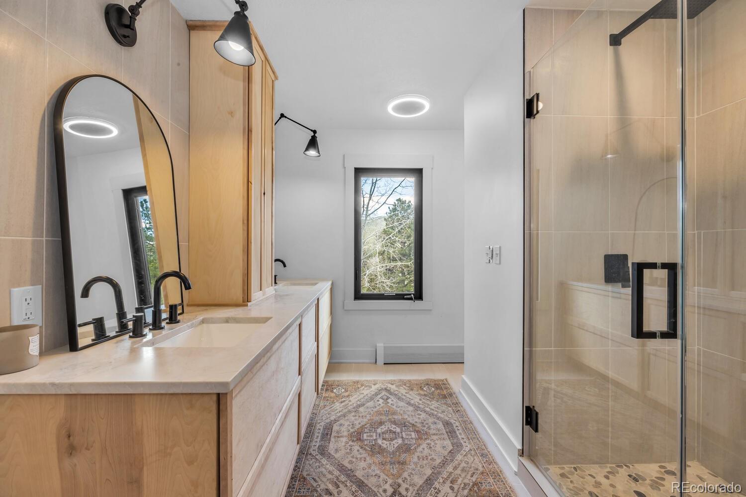 22398 Blue Jay Road Morrison, CO 80465 - Photo 19 of 39 a bathroom with a double vanity sink mirror and shower