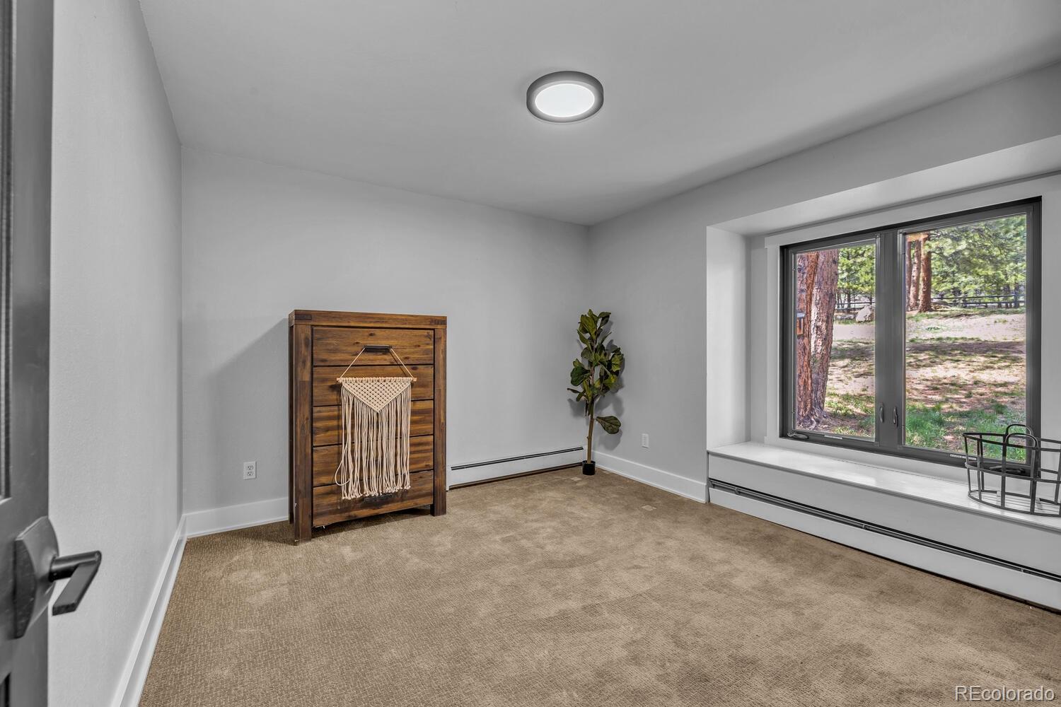 22398 Blue Jay Road Morrison, CO 80465 - Photo 21 of 39 an empty room with windows and closet