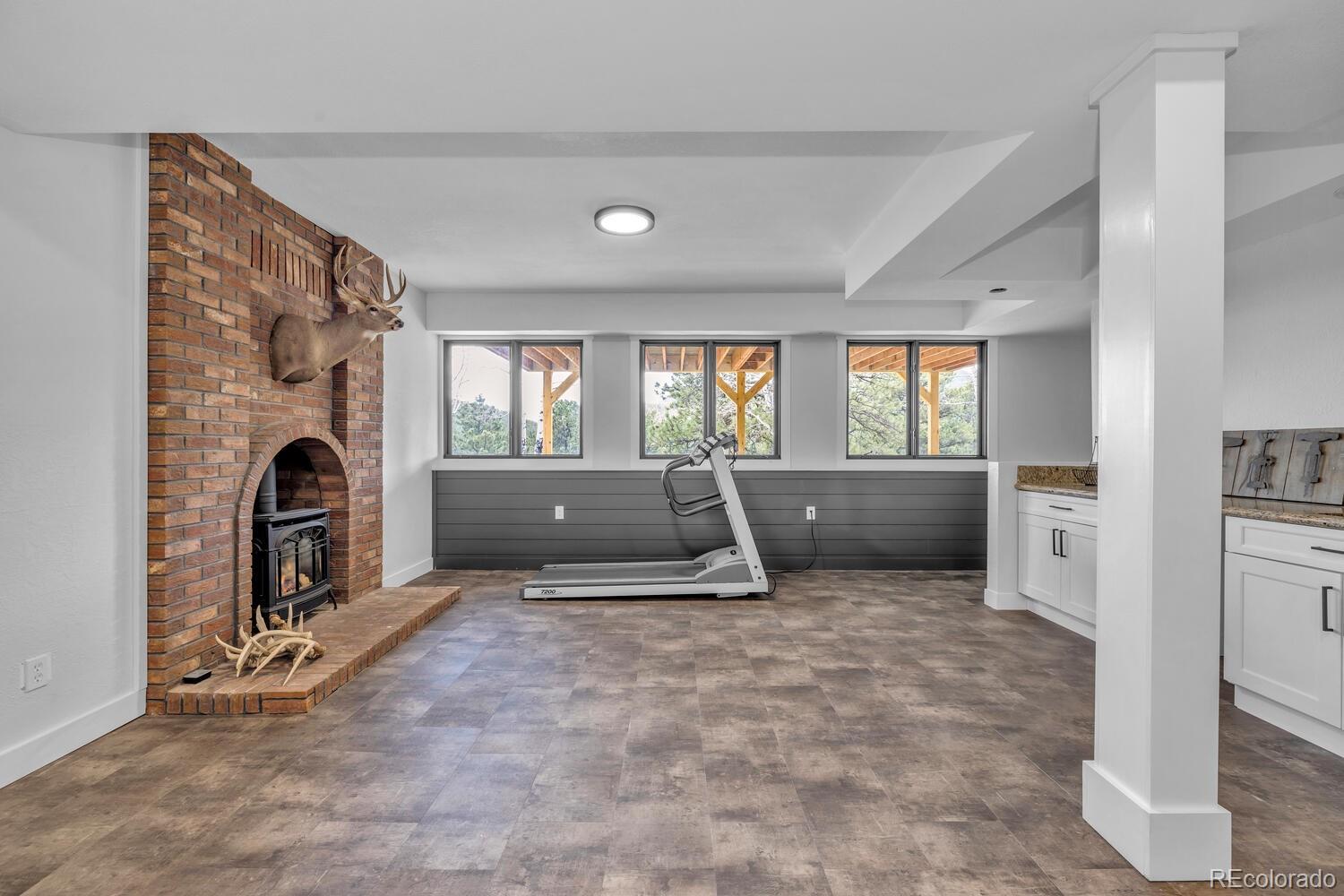 22398 Blue Jay Road Morrison, CO 80465 - Photo 23 of 39 a view of an empty room with a fireplace and a window