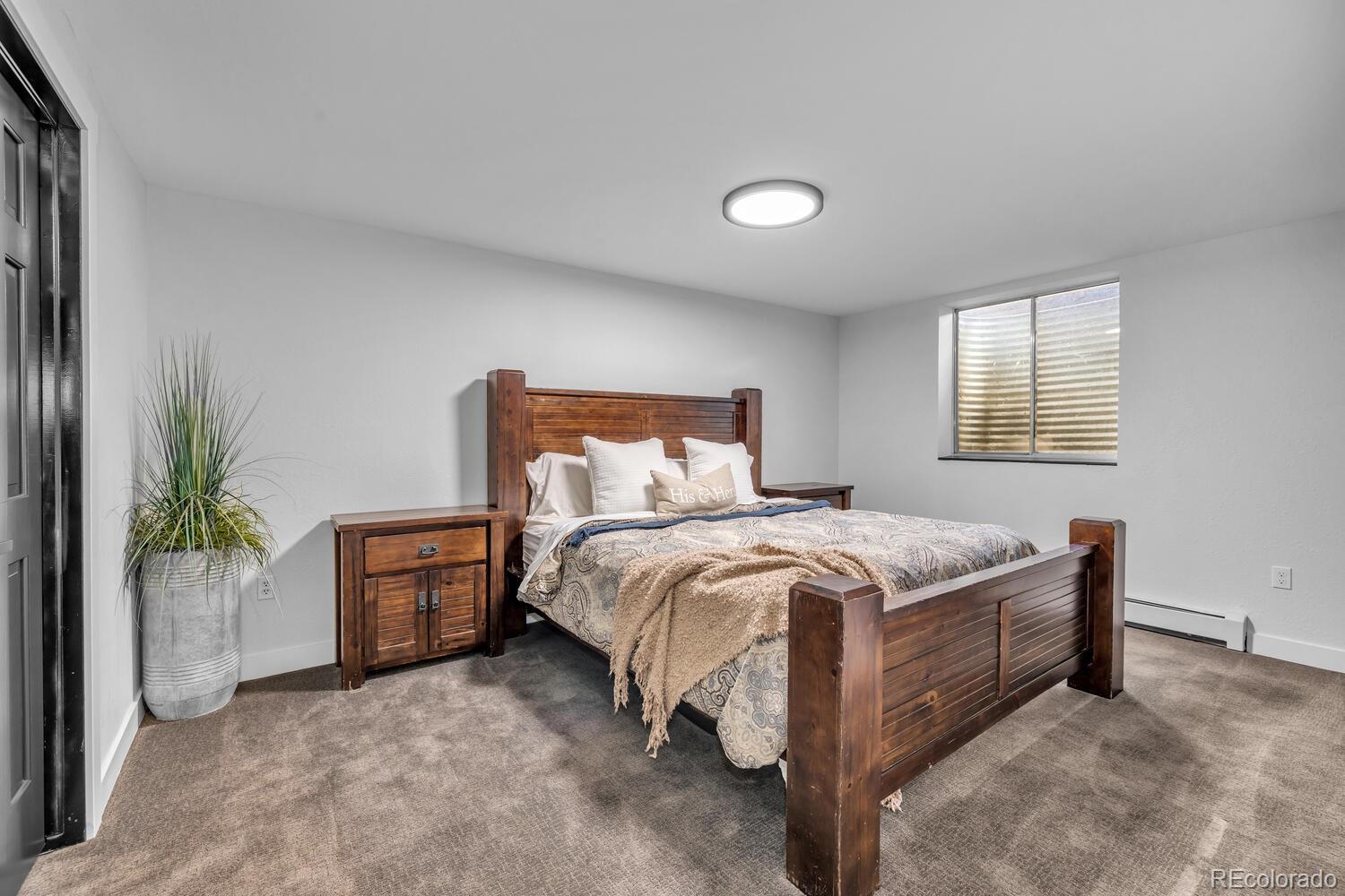 22398 Blue Jay Road Morrison, CO 80465 - Photo 27 of 39 a bedroom with a bed and a potted plant