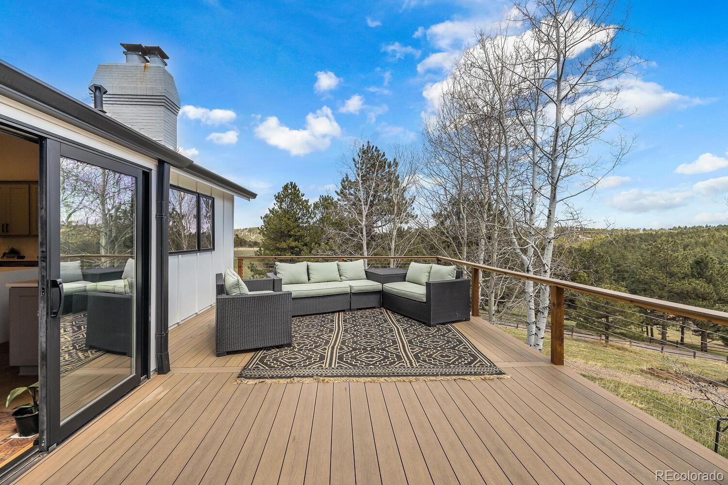 22398 Blue Jay Road Morrison, CO 80465 - Photo 32 of 39 a view of a balcony with furniture and wooden floor