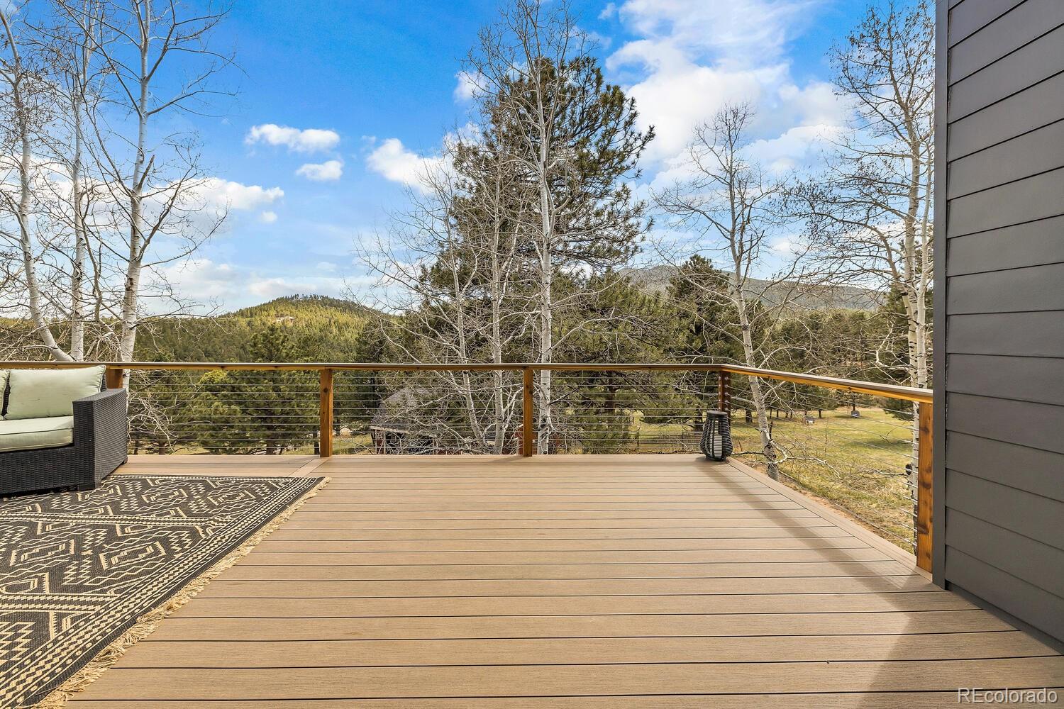 22398 Blue Jay Road Morrison, CO 80465 - Photo 34 of 39 a view of a balcony with wooden floor and fence