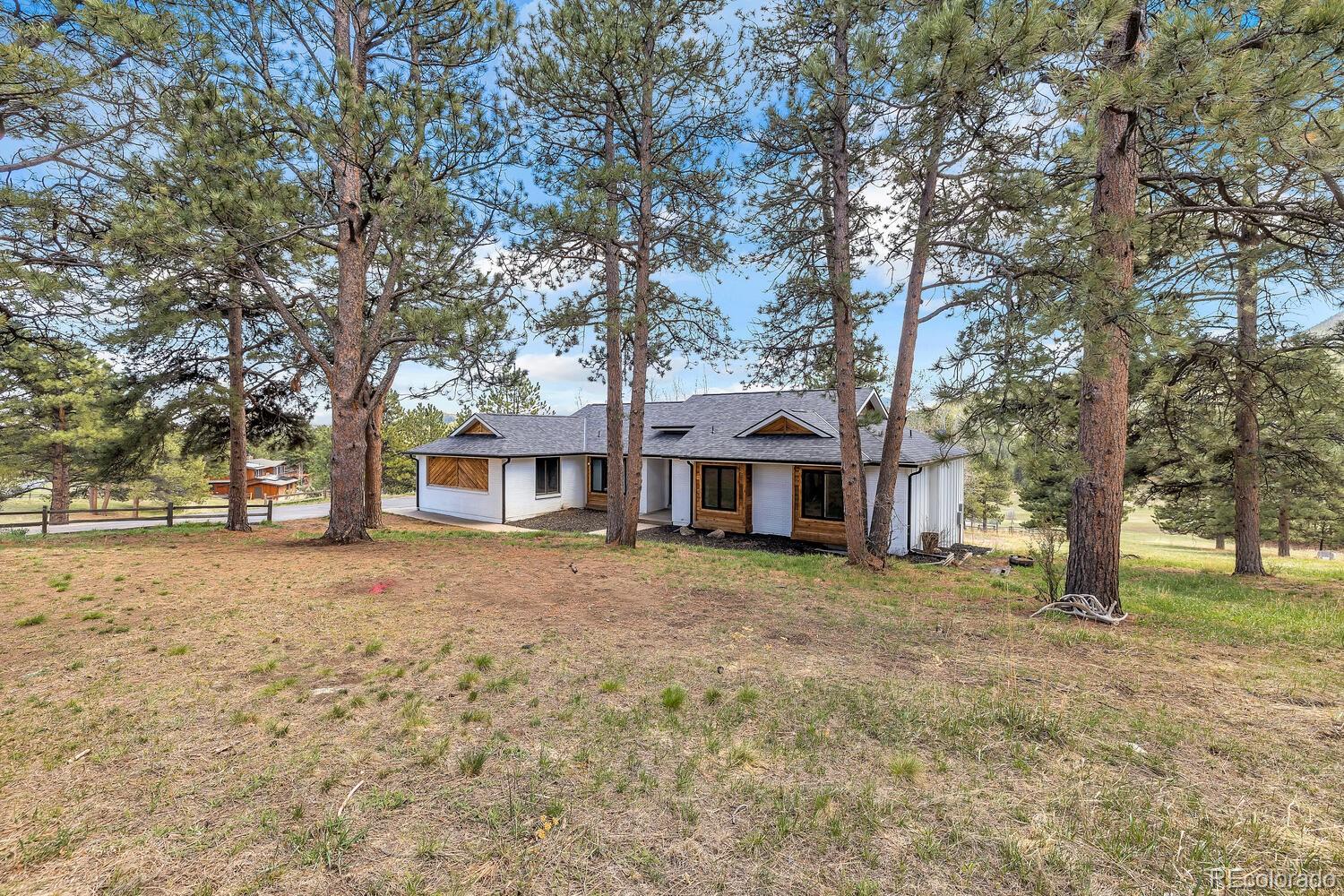 22398 Blue Jay Road Morrison, CO 80465 - Photo 39 of 39 a tree in front of a white house