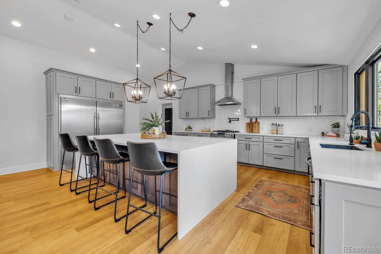 22398 Blue Jay Road Morrison, CO 80465 - Photo 7 of 39 a kitchen with stainless steel appliances kitchen island granite countertop a sink a stove a refrigerator cabinets and chairs