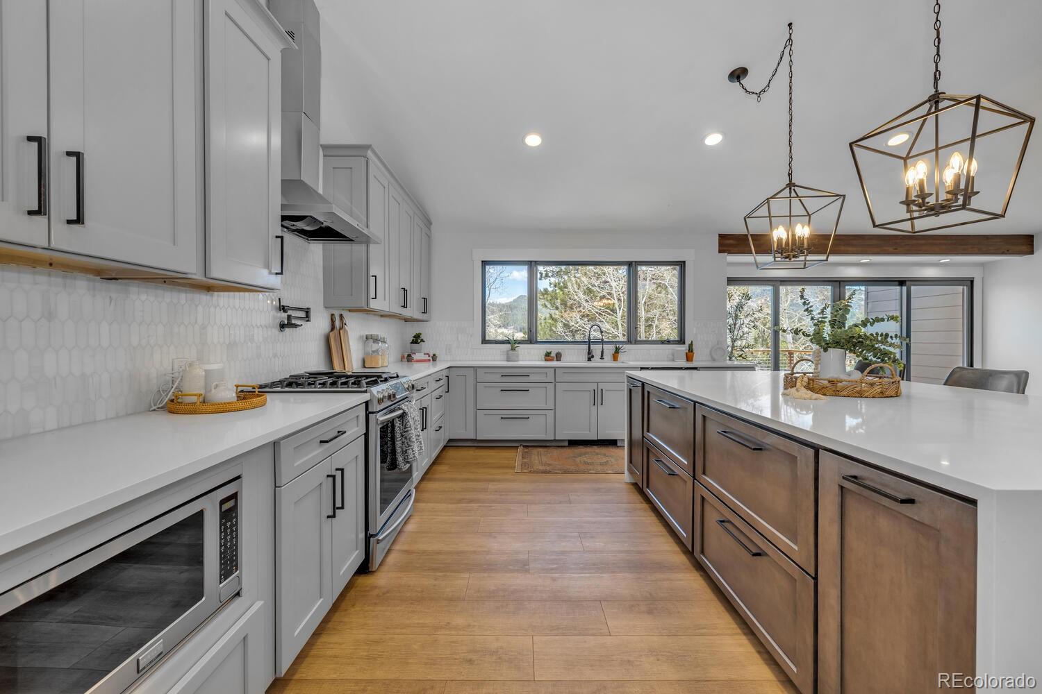 22398 Blue Jay Road Morrison, CO 80465 - Photo 9 of 39 a large kitchen with stainless steel appliances granite countertop a stove and a sink
