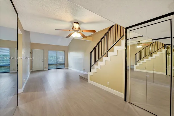 a kitchen with stainless steel appliances granite countertop a refrigerator a stove and a sink with wooden floor