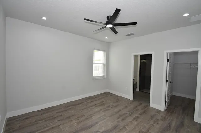 a view of a livingroom with a ceiling fan and wooden floor