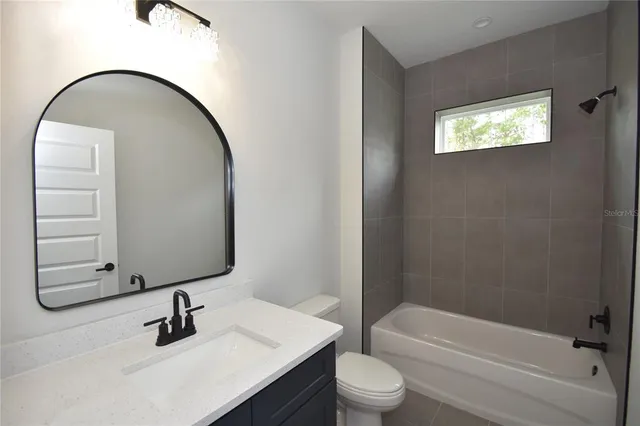 a bathroom with a toilet sink vanity and mirror