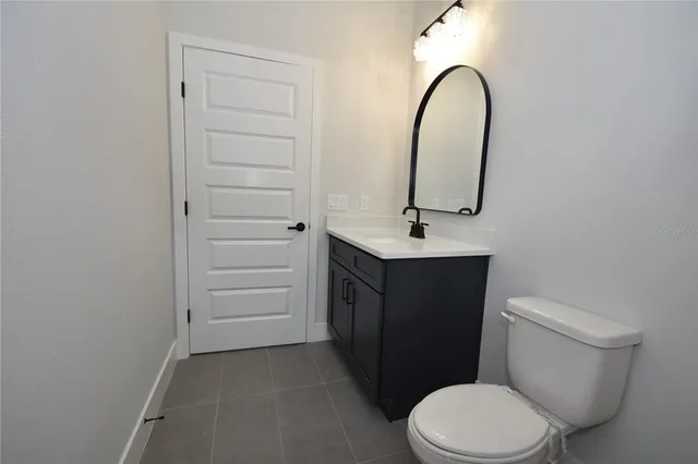 a backyard of a house with plants and large tree