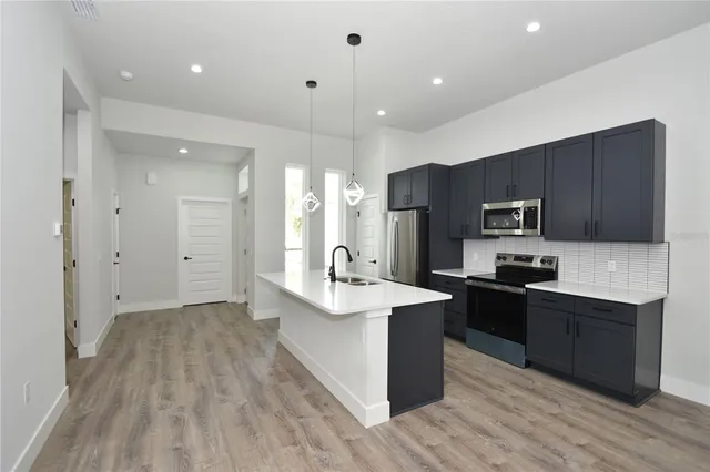 a kitchen with stainless steel appliances granite countertop a sink stove and refrigerator