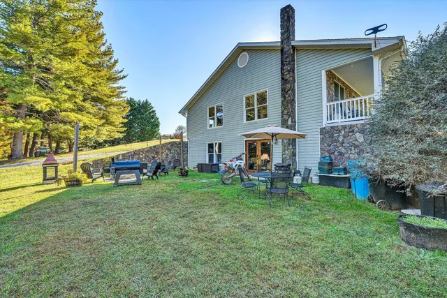 a view of a house with a yard and sitting area