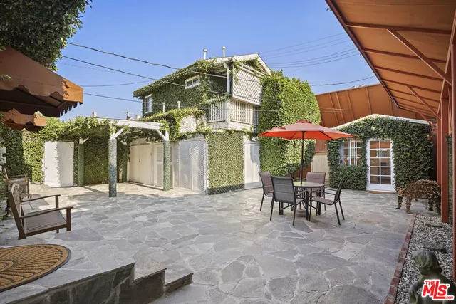 a view of a patio with a table and chairs under an umbrella