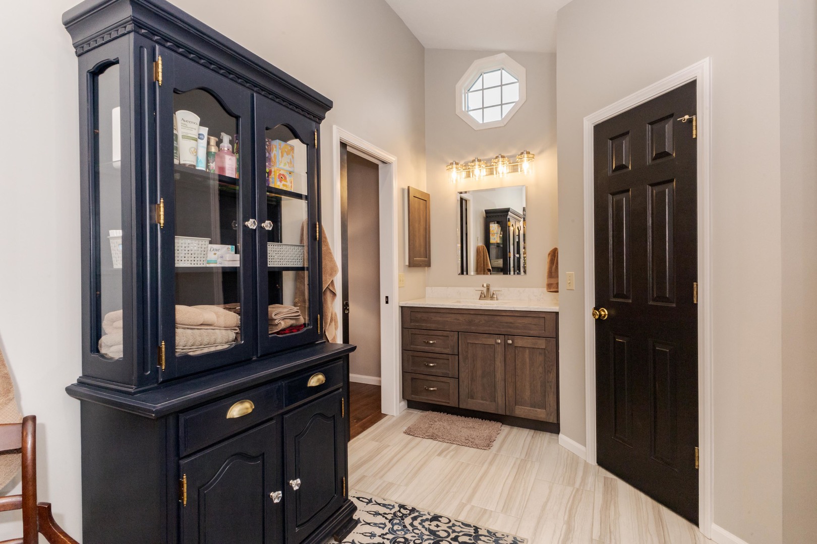 2605 Park Ridge Road Bloomington, IL 61704 - Photo 53 of 69 a bathroom with a vanity a sink a mirror a lamp and bathtub