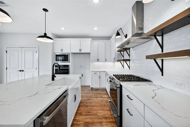 a kitchen with kitchen island stainless steel appliances a stove sink and cabinets