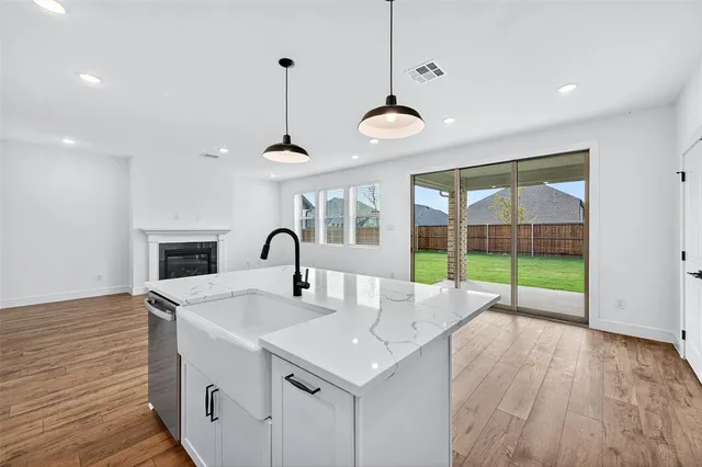 a kitchen with a sink a counter top space and a ceiling fan