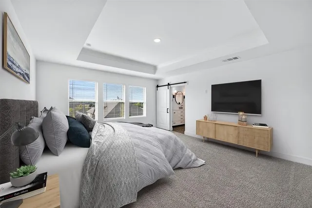 a spacious bedroom with a bed and a flat screen tv