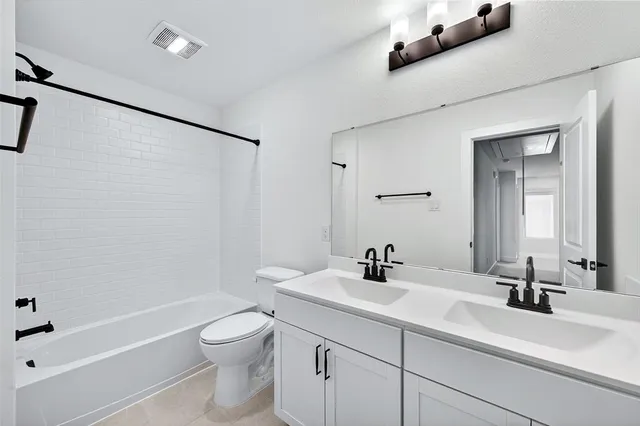 a bathroom with a double vanity sink toilet and shower