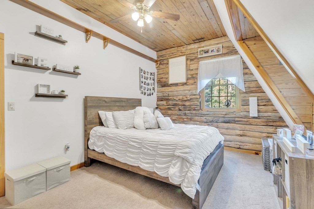160 Laurel Hill Road Westhampton, MA 01027 - Photo 32 of 42 a bedroom with a large bed and a chandelier